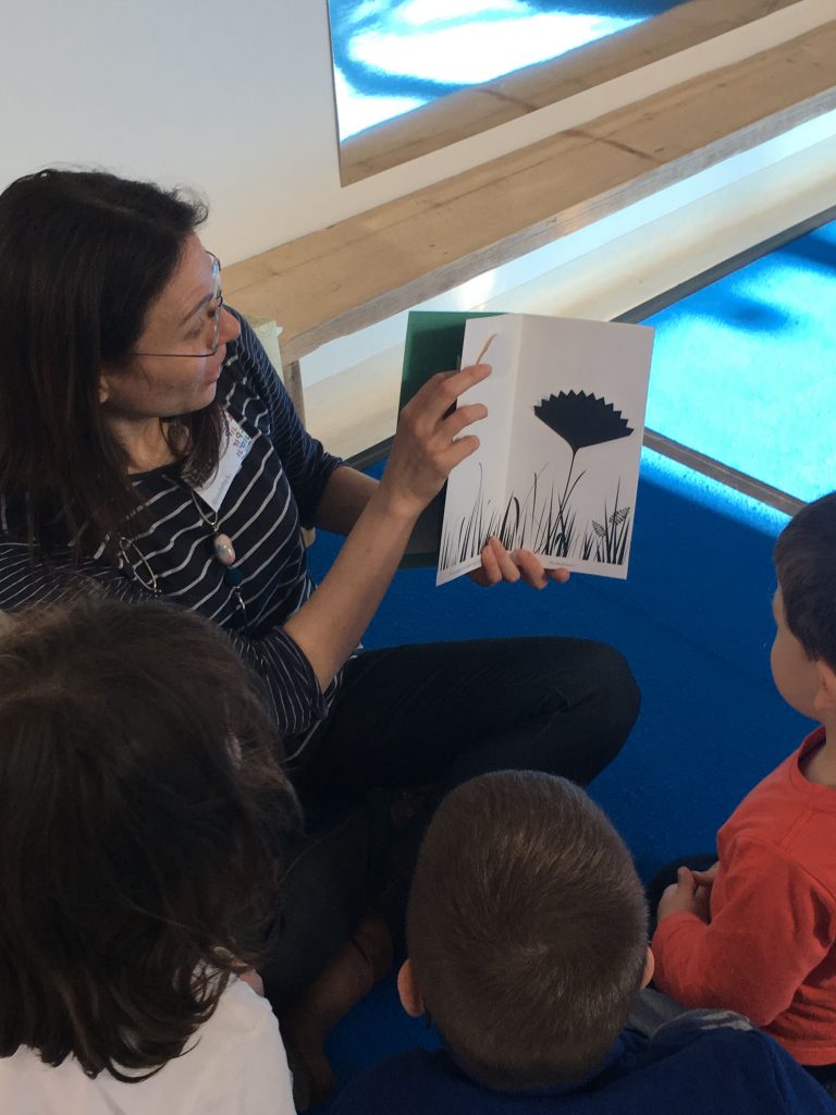 una signora legge un libro a dei bambini